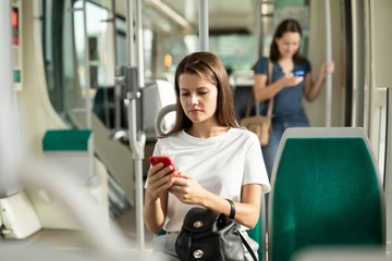 Woman using mobile phone in the cabin of a bus or tram © JackF