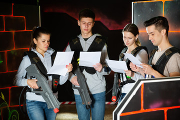 Group of laser tag players read a contract and game conditions