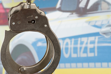 Handschellen und ein Polizeiwagen