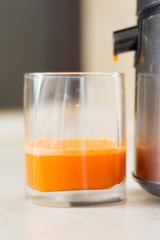 the process of making juice in the home kitchen. Healthy detox, vegetarian diet. A glass of fresh carrot juice. vegetables smoothies, healthy juicy vitamin drink diet. refreshing fruit drink