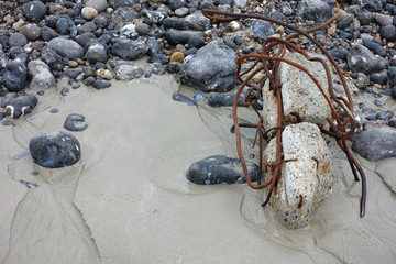Plage polluée par du béton et du métal rouillé