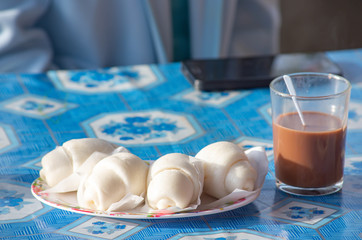Chinese steamed bun or .mantou In a plate and Beverages Hot Chocolate on the table.