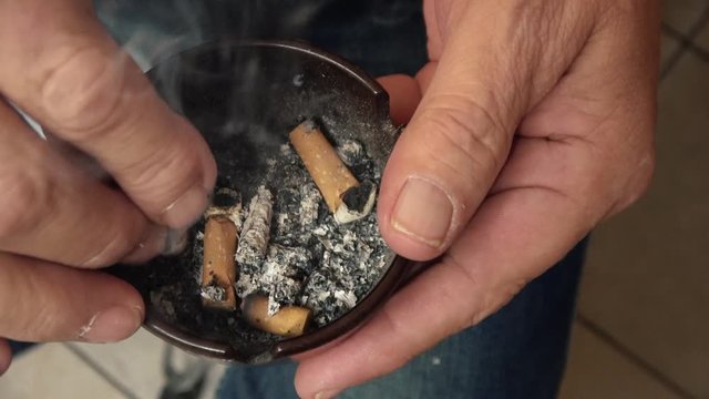 eine qualmende Zigarette wird im Aschenbecher ausgedr&uuml;ckt