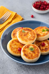 Syrniki or cottage cheese pancakes with fresh red currant. Tasty healthy breakfast.