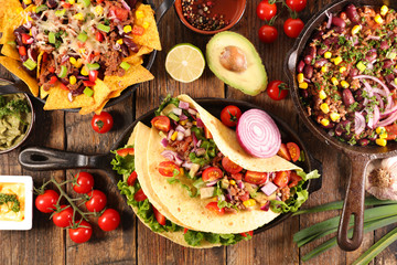 assorted of mexican food with fajitas, chili con carne and nachos with avocado, beef and cheese
