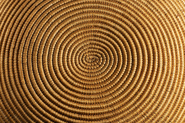 Background of a spiral woven wicker texture - Detail of a brown and orange basket