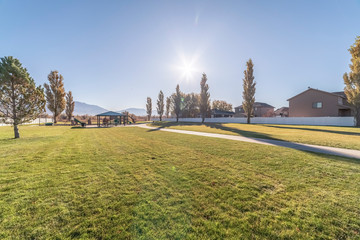 Fototapeta premium Paved pathway through neat green lawns near sunrise