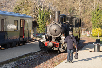 Passager regardant une vieille locomotive à vapeur