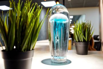 blue jellyfish in a glass form, next to three that grows in pots, decorations