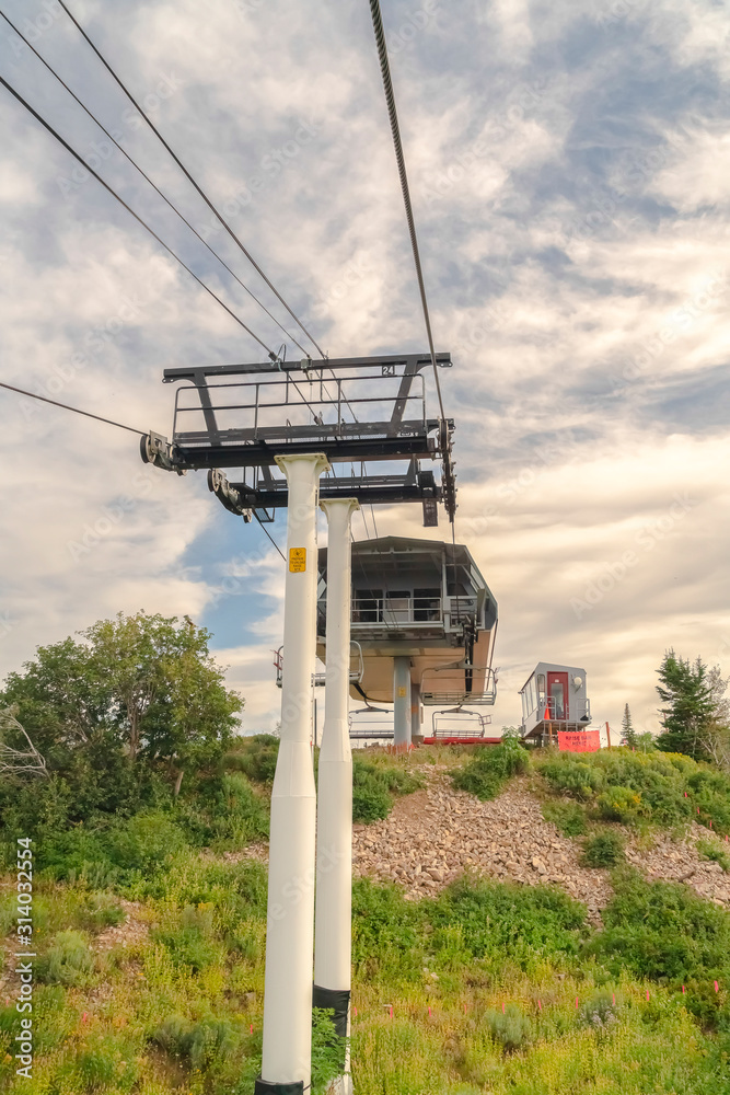 Wall mural chairlift on top of mountain against cloudy blue summer sky in park city utah