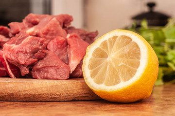 Lemon in the kitchen and raw meat for stew.