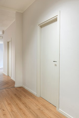 Office entrance with white wooden doors and wood flooring