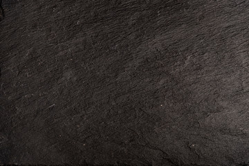 Dark gray black slate background or texture of natural stone. Black board for serving close-up