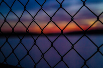 Fototapeta premium sunset through a fence