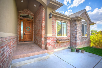 Brick house with arched entrance leading to front door with sidelight and wreath