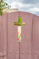 Wooden garden gate leading to church on a cloudy day