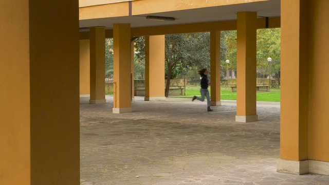 pacman effect - young woman running in the courtyard of building