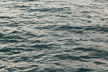 Obraz premium Clear water texture in blue. Background of the ocean and the sea backlit by the sun.