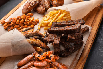 Snack to beer, on a wooden board. Shrimp. Fried fish. Fried peanuts. Fries. Chicken wings.Crunches. Croutons.