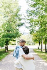Fototapeta premium Married couple walking in the park hugging.