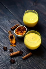 Golden milk turmeric latte with curcuma powder and ingredients. Traditional Indian drink turmeric milk. Top view, space, selective focus