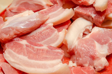 Medium-sized chunks of fresh raw pork red meat on a kitchen plank close-up. Preparation of barbecue, roast, meat dishes, food, pork. Background texture.