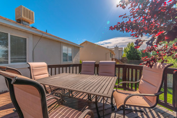 Table and chairs on the balcony of a home with stairs going down to the yard