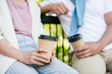 Close up of a couple drinking coffee in the park.