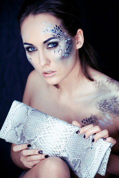 Fashion Portrait Of Pretty Young Woman With Creative Make Up Like A Snake, Fashion Victim With Python Skin Clutch Luxury