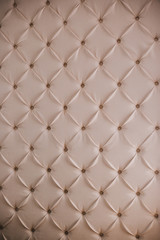 Wall with white leather upholstery. Relief wall. Furniture texture