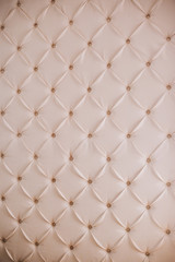 Wall with white leather upholstery. Relief wall. Furniture texture