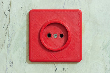 Old broken electrical socket red of wall. A violation of electrical safety