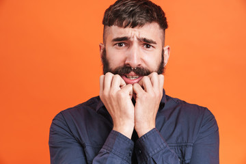 Image closeup of uptight man with nose jewelry grabbing his face in fear