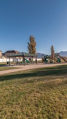 Fototapeta na wymiar Vertical frame Kids playground and picnic area in an urban park