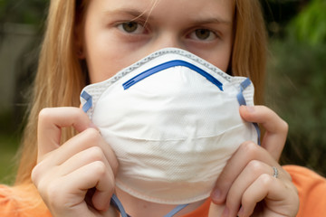 Australian bushfire: blond girl wearing P2 N95 protection respiratory mask to reduce amount of...
