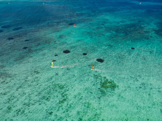 Obraz premium Kiter and windsurfer in tropical ocean at paradise Mauritius. Aerial view.