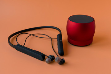 Wireless bluetooth devices for the phone, black headphones and a red speaker. Headset for phone on...