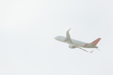 Low angle view of commercial plane taking off in cloudy sky