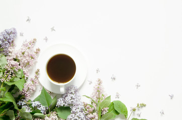 Lilac flowers with cup of coffe on white background. Spring flowers. Top view, flat lay, copy space. - Image