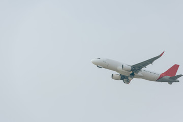 Airplane taking off with cloudy sky at background