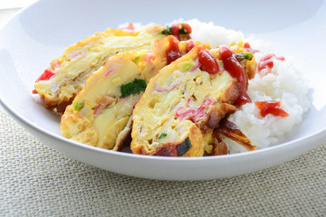 Sliced omelette with soft tofu, crab stick and spring onion with rice on dish