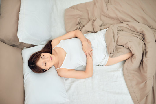Beautiful young Asian woman sleeping in bed