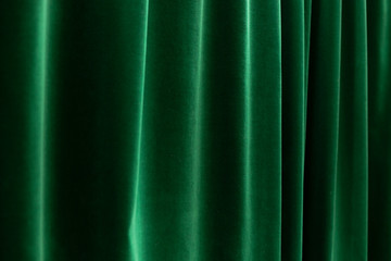 dark depp green curtains with soft folds - horizontal close up photo with selective focus. Perfect background