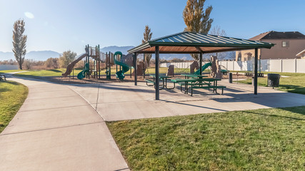 Naklejka premium Panorama frame Covered picnic area and kids playground near sunrise