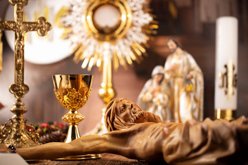 Catholic concept background.  The Cross, monstrance, Jesus figure, Holy Bible and golden chalice on...