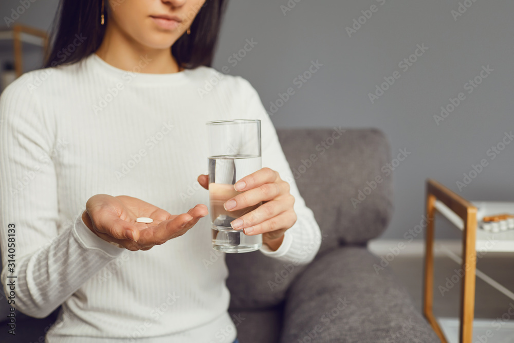 Wall mural Pills tablet in hand of the girl in the room. Concept virus cold pill sick flu sickness headache flu illness