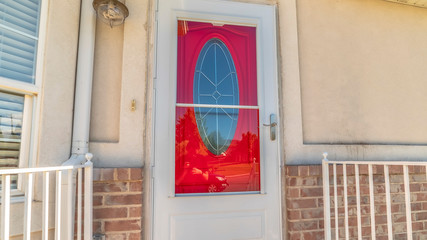 Pano Exterior of a home with decorative oval glass paned vibrant red front door