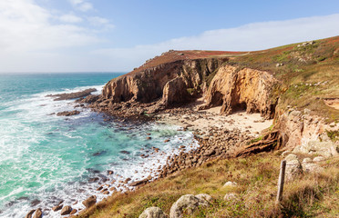 Rocky beach with caves in Mill Bay, Cornwall, England.
