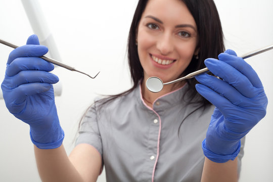 The dentist is holding tools in his hands. Concept photo for dental clinics.