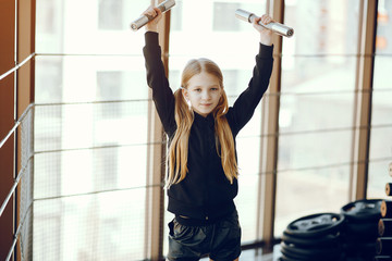 Beautiful girl in the gym. Child performs exercises.